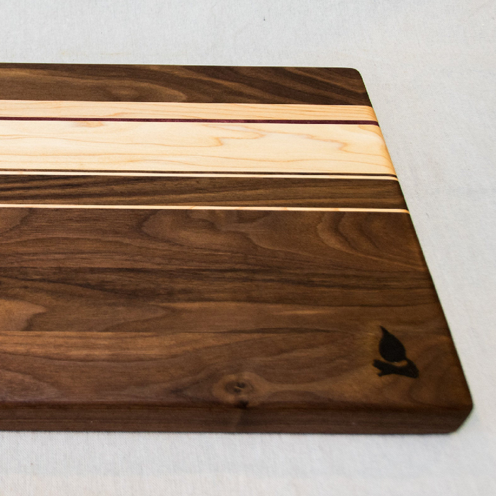 Walnut with stripes of Maple, and Purple Heart Cutting Board