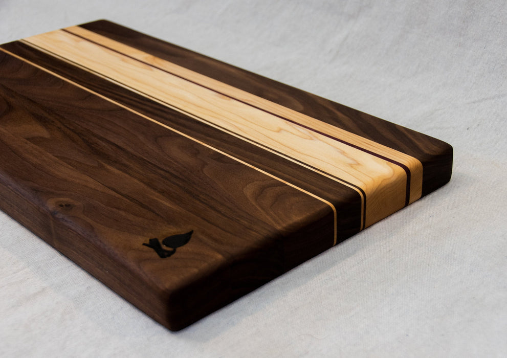 Walnut with stripes of Maple, and Purple Heart Cutting Board