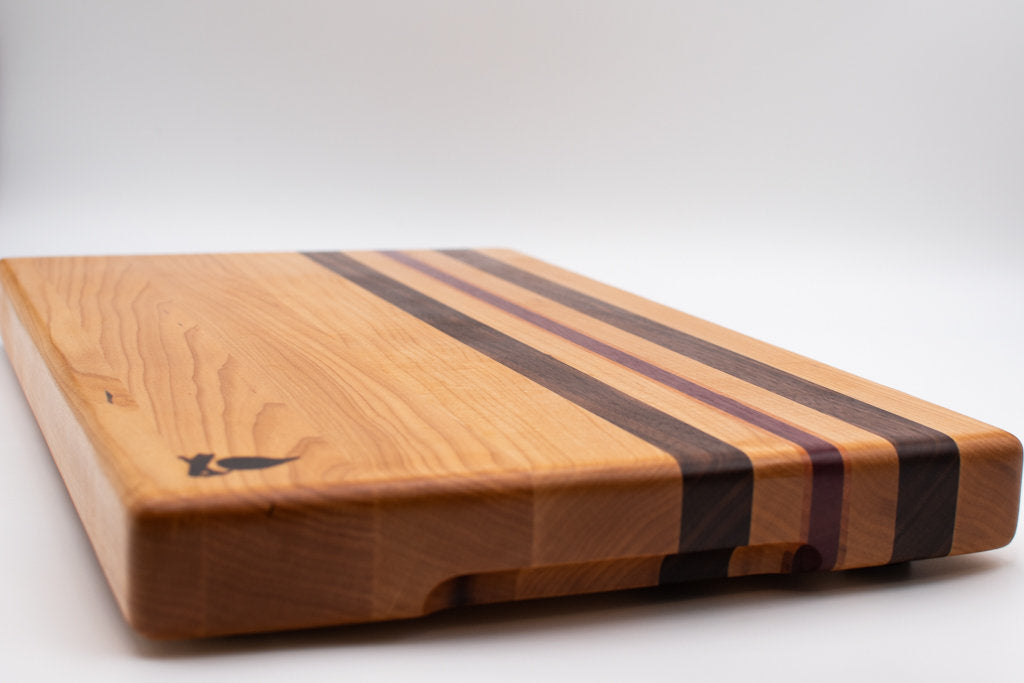 Maple with stripes of Walnut, Cherry, and Purple Heart Cutting Board